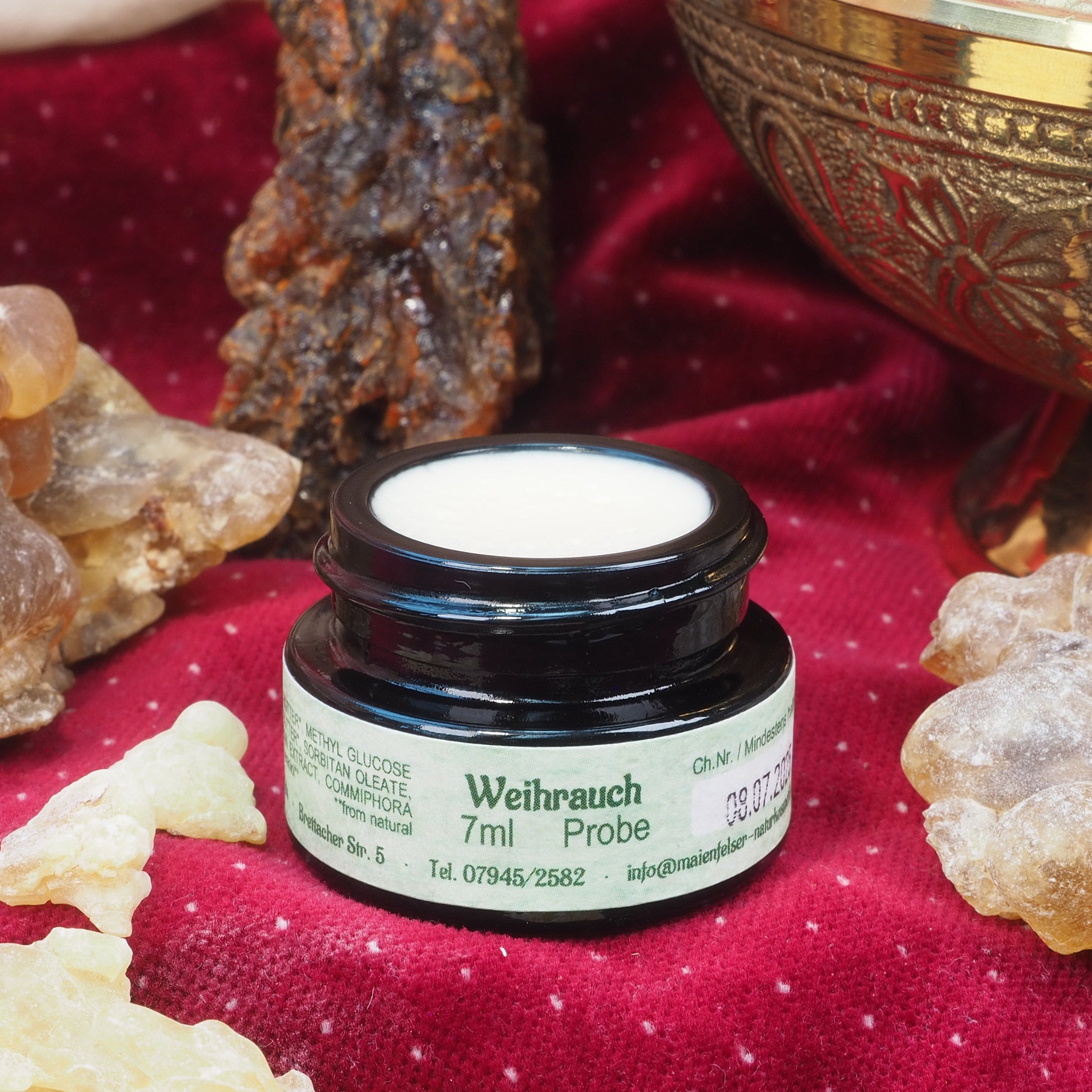 Geöffneter 7ml Weihrauch Creme Tiegel. Danben liegen Weihrauchharz Stücke.